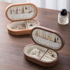 two open jewelry boxes sitting on top of a wooden table