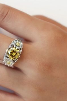 a woman's hand with a yellow and white diamond ring