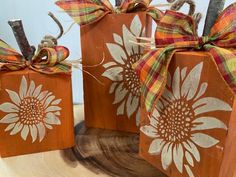 three wooden boxes decorated with sunflowers and twine tied to wood planks