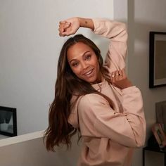 a woman posing with her arms behind her head