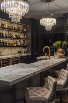 an elegant bar with chandeliers and marble countertops in a dark colored room