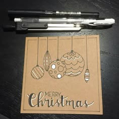 a pen sitting next to a christmas card on top of a table