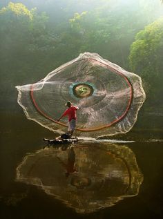 a man standing on top of a river holding a net in his hand with the caption tratemos de vivir de la temodo que despues no tengandos