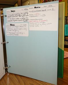 a blue binder with writing on it sitting on a wooden floor next to a door