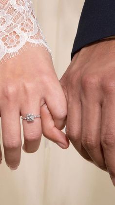 a close up of two people holding hands and touching each other's fingers with lace on them