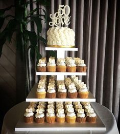 a three tiered cake with cupcakes on it