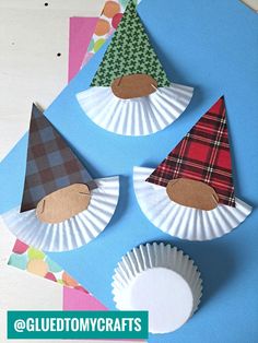 three paper plates with hats on them sitting on top of a blue table cloth covered surface