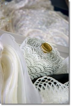 there are many different types of wedding gowns in the box, including one with a gold button on it