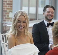 a woman wearing a tiara sitting next to a man in a tuxedo