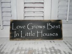 a sign that says love grows best in little houses