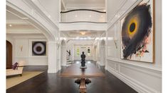 a long table in the middle of a room with paintings on the walls and stairs