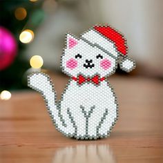 a white cat with a red hat and bow tie