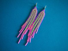 Stripes of neon purple contrast against neon green and blend into hot pink at the tips of the fringes of these very lightweight fringe earrings. They have seven strands of beads measuring 4 1/2 inches long as suspended from sterling silver lever backs with a width of 5/8 inch. Purple Contrast, Neon Stripes, Seed Bead Patterns, Bead Projects, Neon Purple, Pink Neon, Beaded Fringe, Fringe Earrings, Bead Patterns