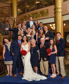 a large group of people posing for a photo in front of a spiral stair case