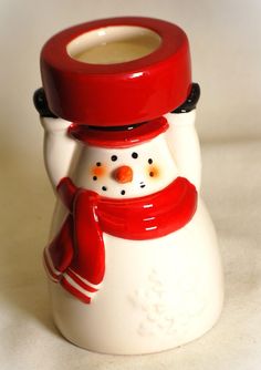 a red and white ceramic snowman candle holder