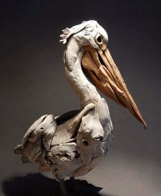 a sculpture of a pelican is shown on a gray background with shadow from the bird's head