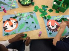 two children are sitting at a table making paper cutouts with animals and leaves on them