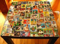 a table with many different baseball cards all over it and a light in the background