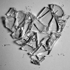 ice cubes are arranged in the shape of a heart on a white surface with water droplets