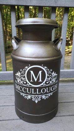 a large metal urn sitting on top of a porch next to a wooden fence