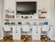 two white chairs sit in front of a desk with a flat screen tv on it