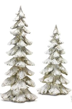 two silver christmas trees are standing next to each other in front of a white background