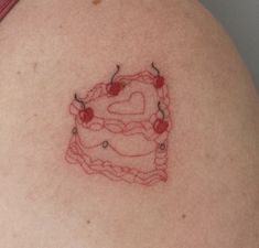 a woman's stomach with a heart shaped cake tattoo on her left side shoulder