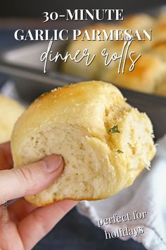 a hand holding a piece of garlic parmesan dinner rolls