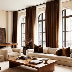 a living room filled with lots of furniture next to large window covered in brown drapes