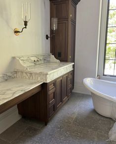 a bathroom with marble counter tops and wooden cabinets