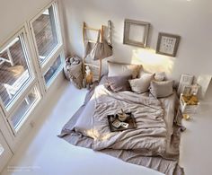 an aerial view of a bed with pillows and blankets on it, next to two windows