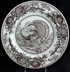 a brown and white plate with a turkey design on it's side, in front of a black background