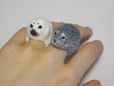 two small stuffed animals sitting on top of a person's hand