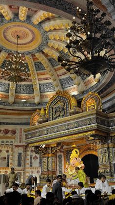 an elaborately decorated room with chandeliers and paintings on the ceiling is filled with people