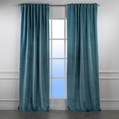 a blue curtain hanging on the side of a window in a room with white walls