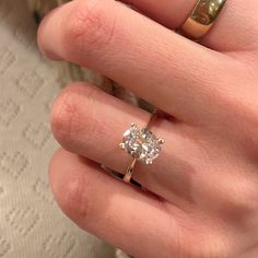 a woman's hand with a ring on it and a diamond in the middle