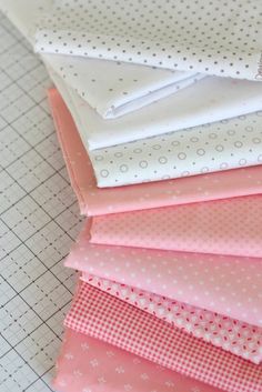 a pile of pink and white fabric sitting on top of a cutting board