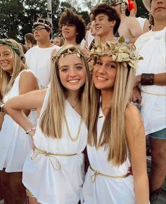 two girls in white dresses standing next to each other