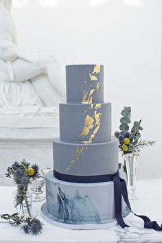 a blue and gold wedding cake on a table