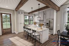 a large kitchen with white cabinets and wood flooring, along with an island in the middle