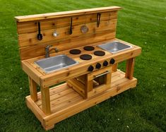 an outdoor kitchen made out of wooden pallets with two sinks and cooking utensils