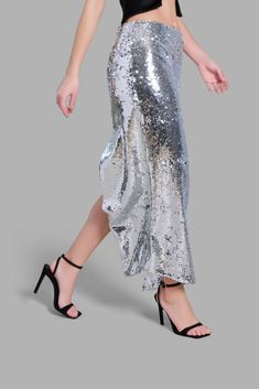 This mid-rise Silver Sequin Diagonal Maxi Skirt has an asymmetrical cut at the bottom. This skirt is noted for its uniqueness in design and its versatility. This product is styled with the Black Satin Arc-Cut Top.