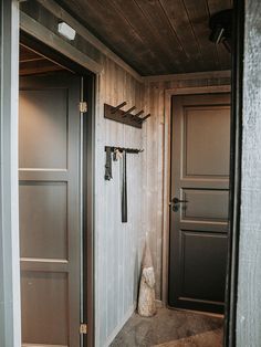 two doors are open in a room with wood paneling on the walls and floor