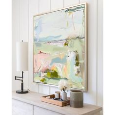 an abstract painting hangs on the wall above a dresser