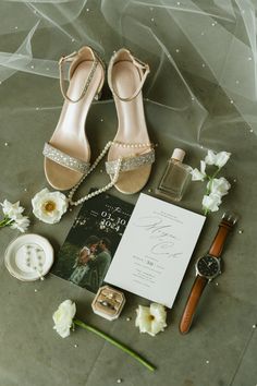 the bride's wedding shoes, ring, and jewelry are laid out on the floor