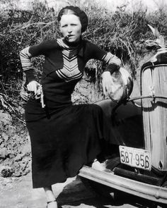 a woman leaning on the hood of an old car