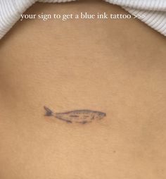 a woman's stomach with a fish tattoo on it