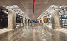 an empty building with marble floors and columns in the center is lit by red lights