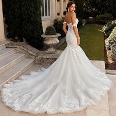 a woman in a wedding dress standing on some steps