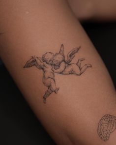 a tattoo on the arm of a woman with an angel and brain behind her back